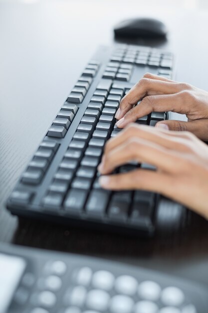 Primer plano de manos femeninas escribiendo en el teclado