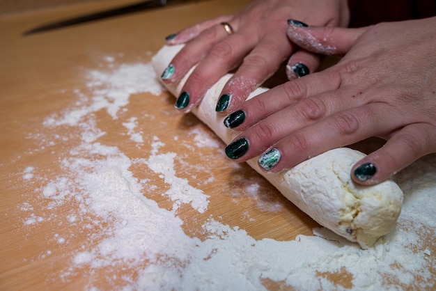 Primer plano de manos femeninas extendiendo masa dulce para hornear