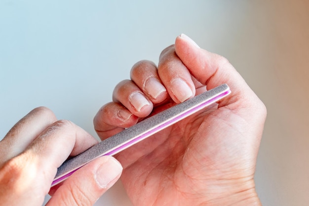 Primer plano de manos femeninas en el proceso de manicura La niña se hace la manicura en casa Du
