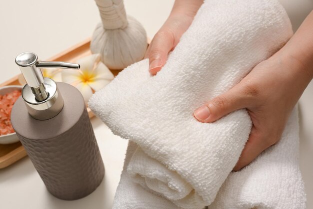 Primer plano Manos femeninas sosteniendo una toalla de spa en una mesa de spa composiciones Tratamiento de spa de aromaterapia