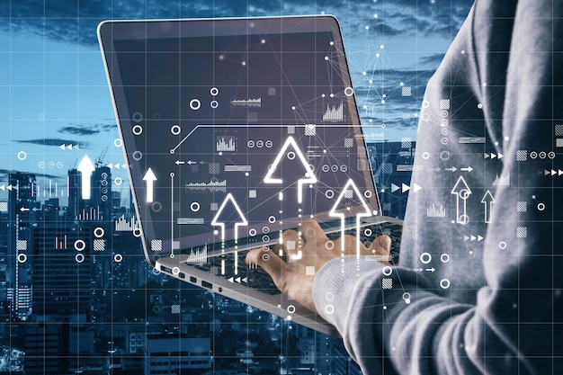 Primer plano de manos de un hombre de negocios usando una computadora portátil con flechas brillantes abstractas en el fondo borroso de la ciudad Negocios futuros y concepto de doble exposición