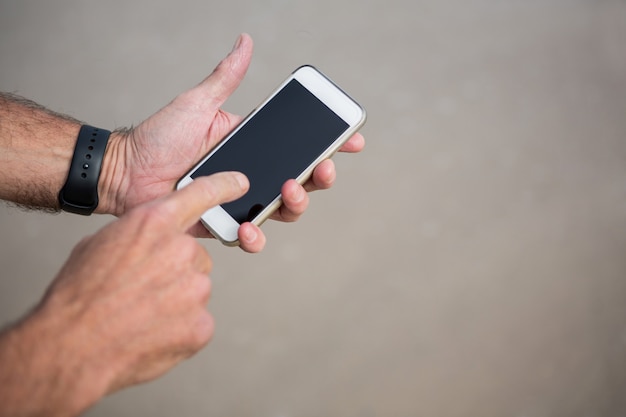 Foto primer plano de las manos del hombre mediante teléfono móvil