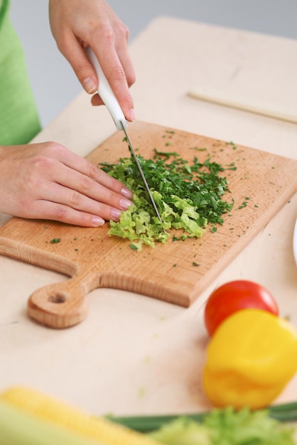 Primer plano de manos humanas cocinando ensalada de verduras en la cocina Comida saludable y concepto vegetariano