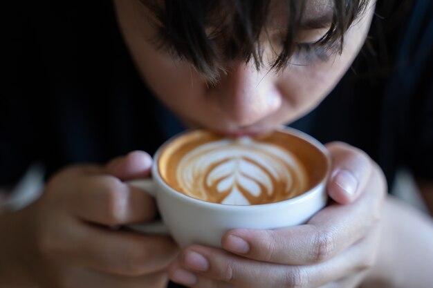 Primer plano de manos Joven sosteniendo una taza de café en un café