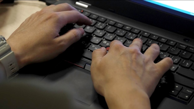 Primer plano de las manos masculinas escribiendo de cerca la vista borrosa de la mano masculina tocando el teclado de la computadora de cerca