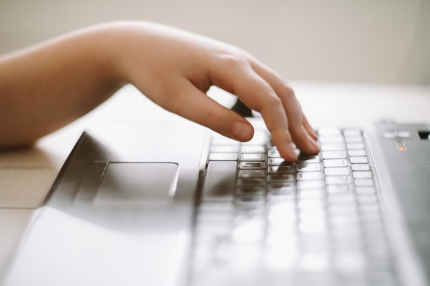 Primer plano de manos masculinas escribiendo en el teclado de la computadora portátil en el interior Empresario que trabaja en la oficina o estudiante que busca datos de entrada de información para el análisis de información y envía un mensaje de correo electrónico