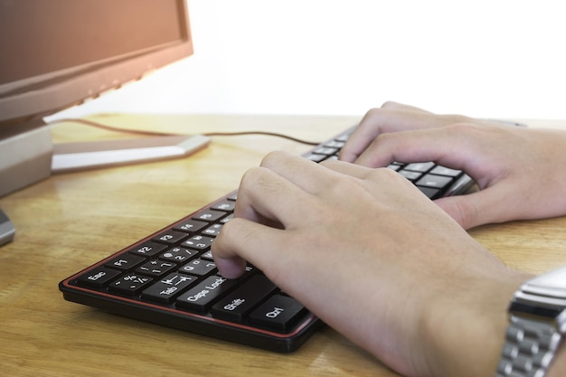 Un primer plano de manos masculinas escribiendo en un teclado negro. Un hombre de negocios trabajando en un concepto de efecto de luz.