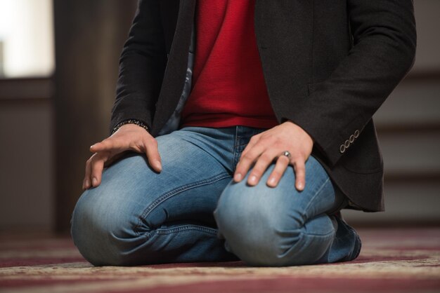 Primer plano de manos masculinas orando en la mezquita