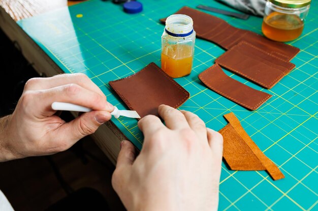 Primer plano de manos masculinas trabajando con cuero natural Productos hechos a mano de cuero genuino