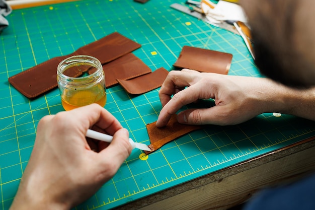 Primer plano de manos masculinas trabajando con cuero natural Productos hechos a mano de cuero genuino
