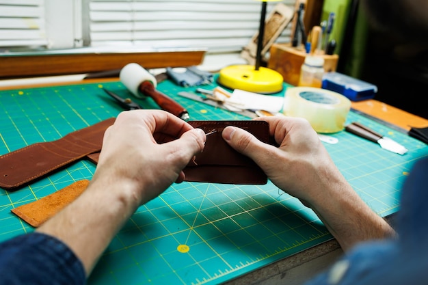 Primer plano de manos masculinas trabajando con cuero natural Productos hechos a mano de cuero genuino