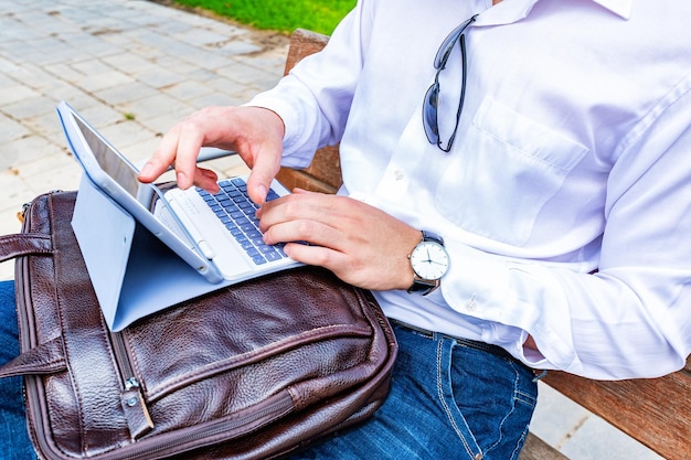 Foto primer plano de manos masculinas trabajando con tableta en el parque