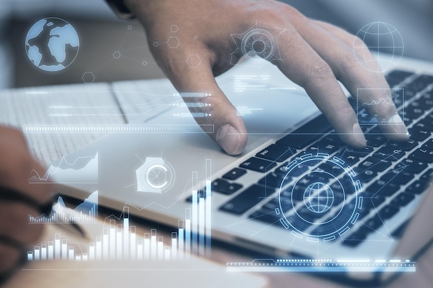 Primer plano de manos masculinas usando una computadora portátil con holograma de gráficos de negocios sobre fondo borroso Control militar economía mundial y finanzas diagrama virtual Doble exposición