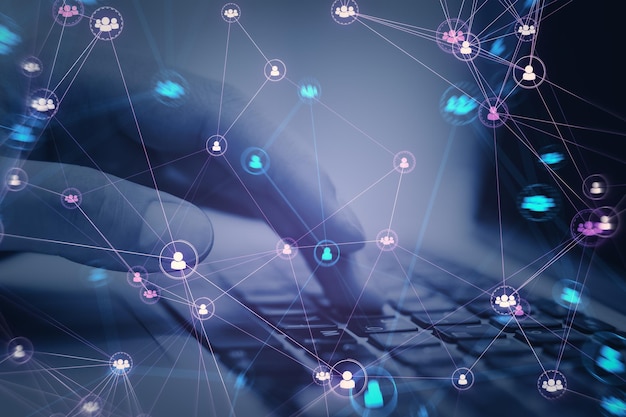 Primer plano de manos masculinas usando una computadora portátil con iconos de equipo de personas digitales conectados sobre un fondo púrpura oscuro y borroso Red digital comunidad en línea y concepto de redes sociales Doble exposición
