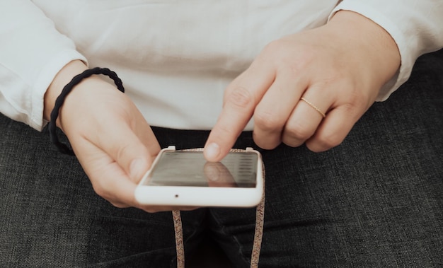 Primer plano de las manos de una mujer consultando un teléfono inteligente