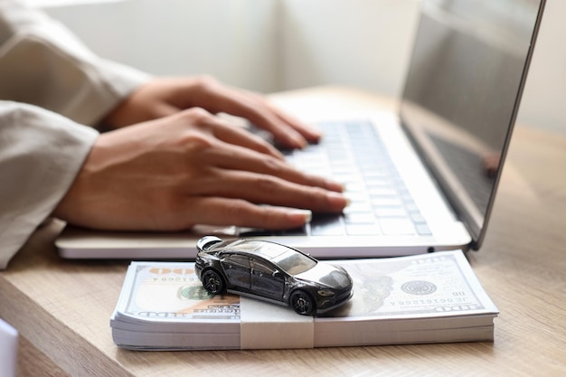Primer plano de las manos de la mujer escribiendo en la computadora portátil solicitando un préstamo de automóvil, finanzas para el concepto de automóvil.