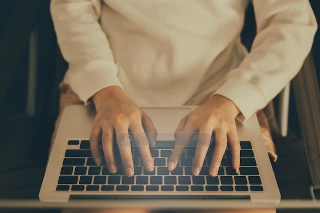 Primer plano de manos de mujer escribiendo en el teclado del portátil