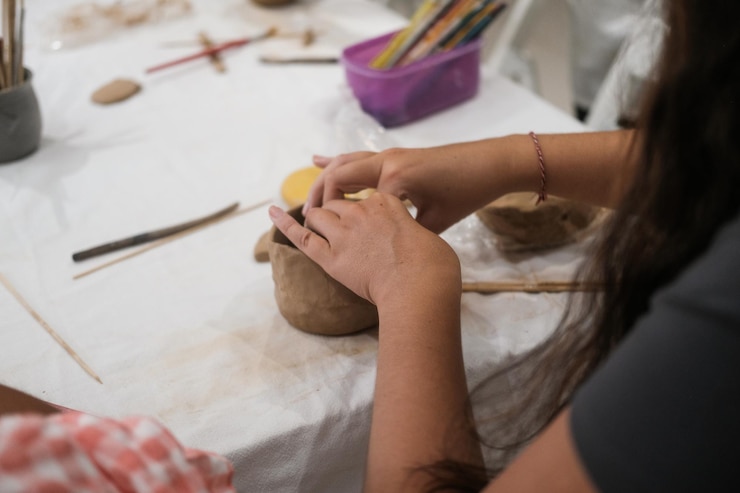Foto un primer plano de las manos de una mujer que esculpe una taza de arcilla en una clase maestra de cerámica