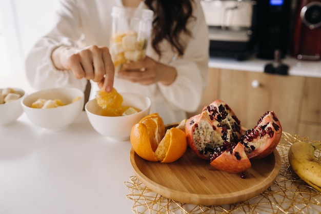 Primer plano de las manos de una niña que hace un cóctel de desintoxicación de frutas en la cocina Dieta para bajar de peso