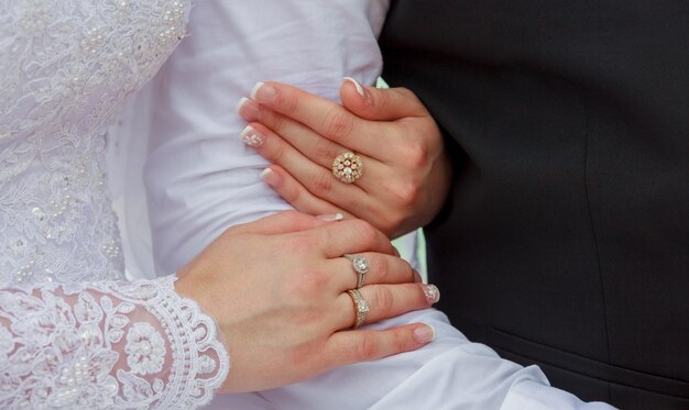 Primer plano de manos nupcial pareja con anillos de boda en el fondo de la naturaleza