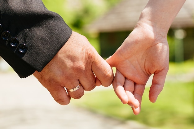 Primer plano de las manos de una pareja unida Foto entonada con poca profundidad de campo. Concéntrese en Ring.