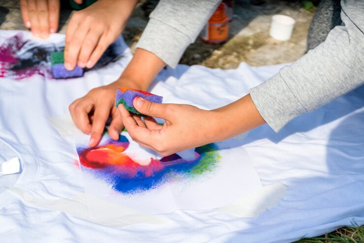 Foto primer plano de manos pintando en una camiseta exterior