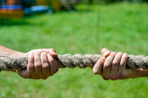 Primer plano de las manos sosteniendo la cuerda en el campo