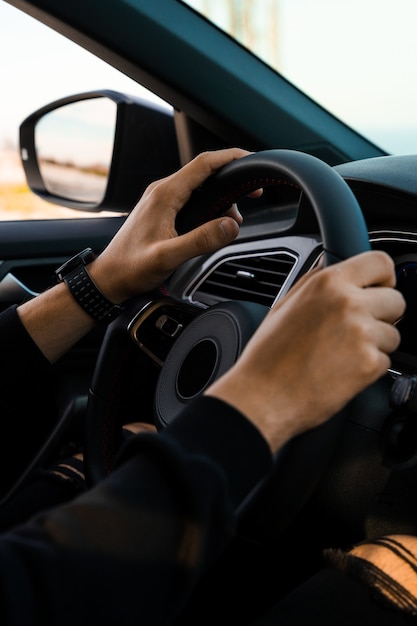 Primer plano de manos sosteniendo el manillar de un coche