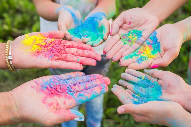 Primer plano de manos sosteniendo a personas de varios colores