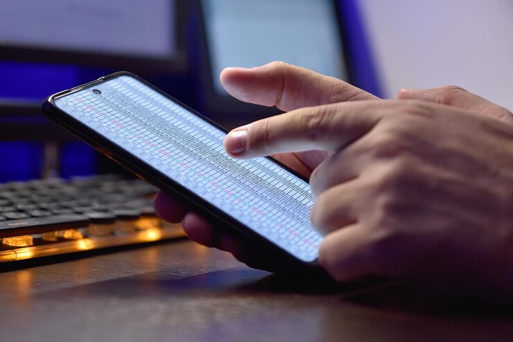 Foto primer plano de manos sosteniendo un teléfono celular con un informe comercial