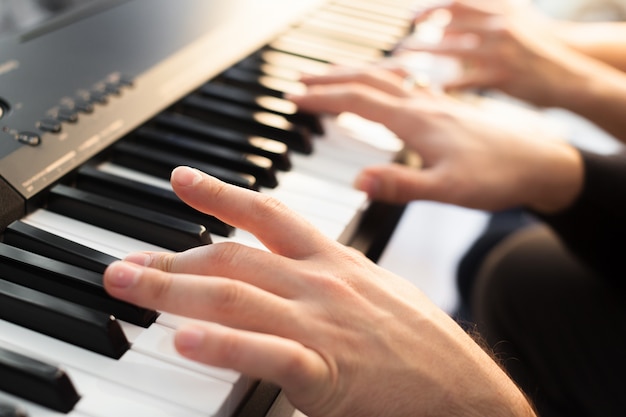 Primer plano de las manos tocando el piano. Concepto de música y hobby