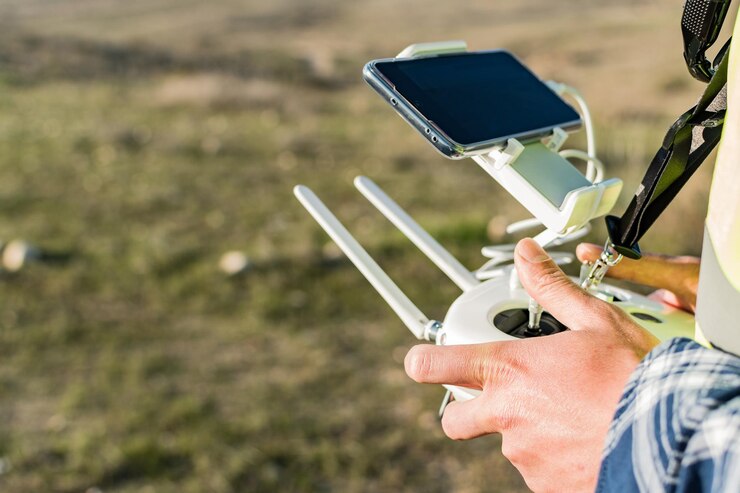 Foto un primer plano de las manos de un trabajador masculino sosteniendo un control remoto con drones en el campo
