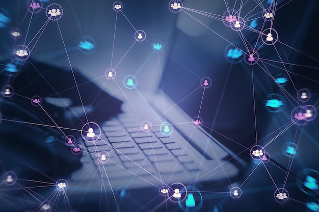 Primer plano de las manos usando una computadora portátil con iconos de equipo de personas digitales conectados sobre un fondo púrpura oscuro y borroso Red digital comunidad en línea y concepto de redes sociales Doble exposición