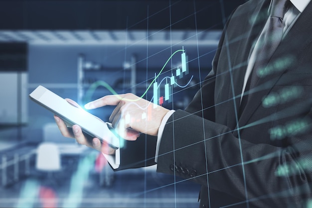 Primer plano de las manos usando el teléfono celular con holograma de gráfico de forex de negocios brillante y cuadrícula en el fondo interior de la oficina borrosa Comercio de finanzas de acciones e inversión concepto Doble exposición