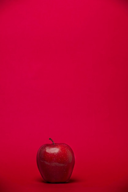 Primer plano de una manzana contra un fondo rojo