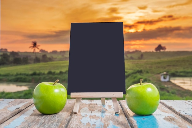 Foto primer plano de una manzana en una mesa verde contra el cielo durante la puesta de sol