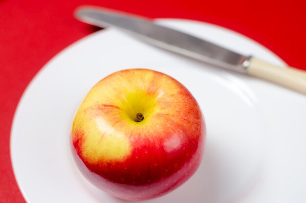Primer plano de una manzana en un plato sobre la mesa