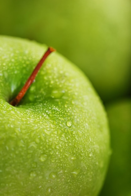 Foto primer plano de manzana verde jugosa con gotas de rocío.