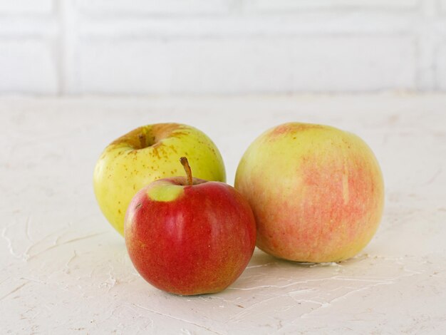 Primer plano de manzanas rojas y amarillas sobre el fondo blanco con textura poca profundidad de campo