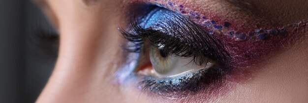 Primer plano de maquillaje de noche brillante en ojos femeninos