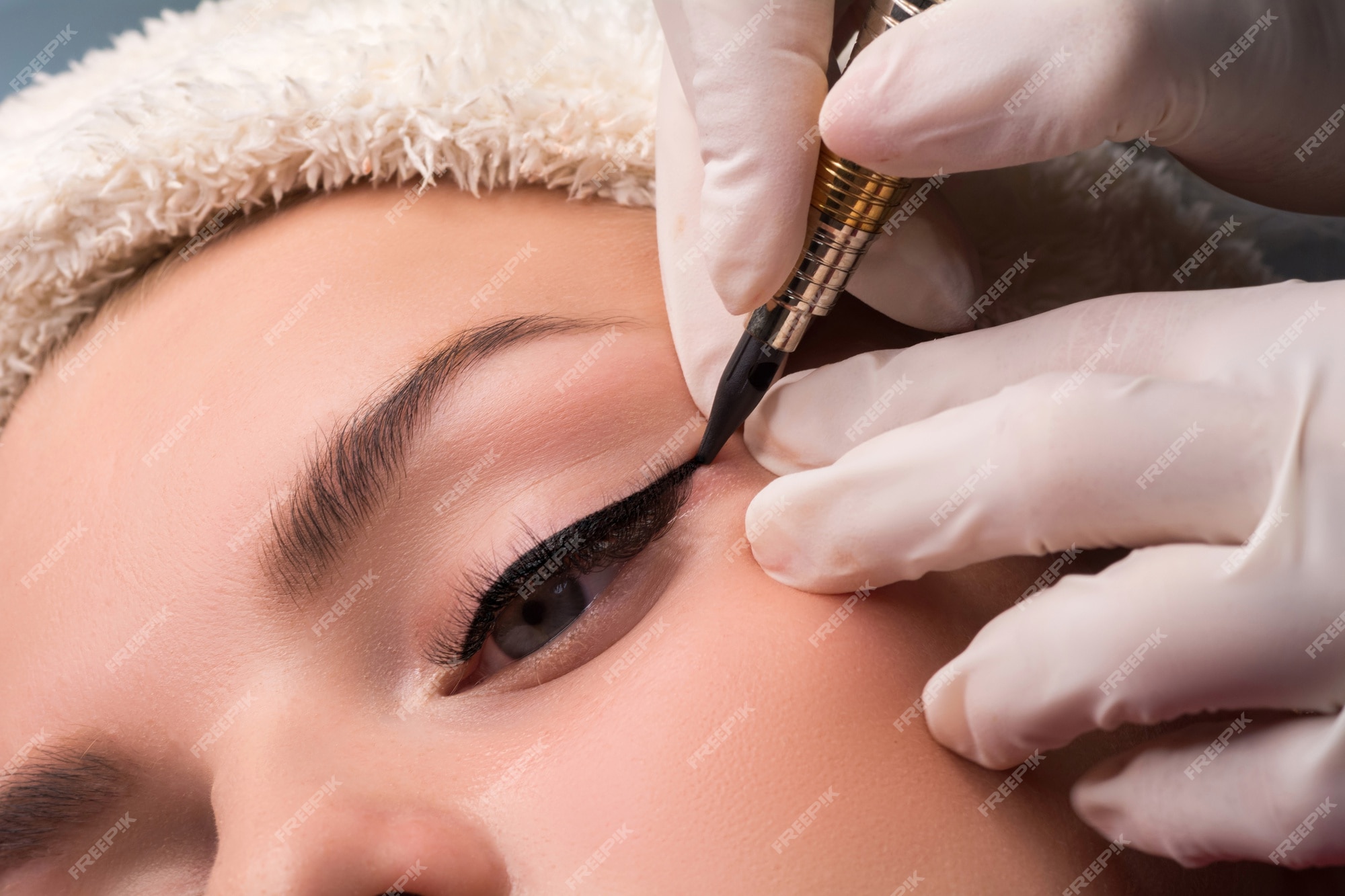 Primer plano de maquillaje de ojos permanente. cosmetóloga aplicando  tatuajes de ojos. | Foto Premium