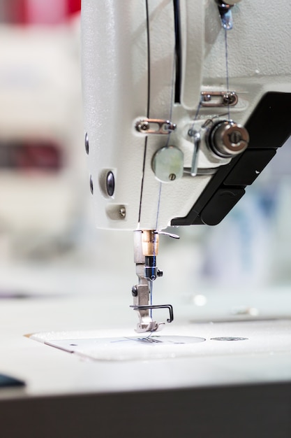 Primer plano de la máquina de coser o overlock, nadie. Producción en fábrica, fabricación de costura.