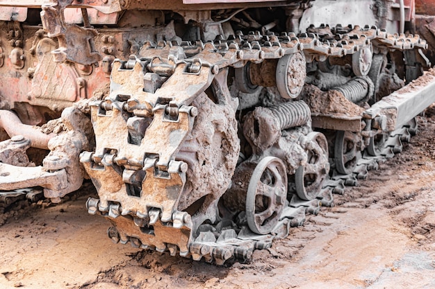 Primer plano de la máquina de orugas de la niveladora. Potentes orugas de excavadora. Maquinaria de construcción para nivelación de terrenos. Maquinaria pesada de construcción.