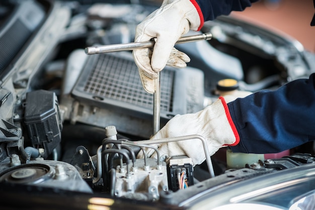 Primer plano de un mecánico de automóviles trabajando en un motor de automóvil