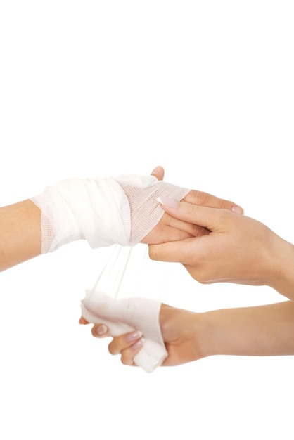 Primer plano de un médico aplicando una tirita sobre un fondo blanco