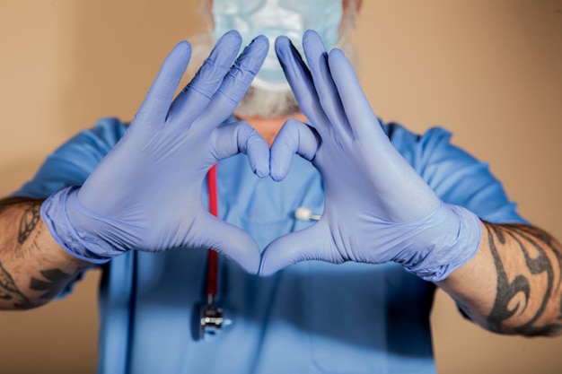 Foto primer plano de un médico haciendo una forma de corazón con sus manos