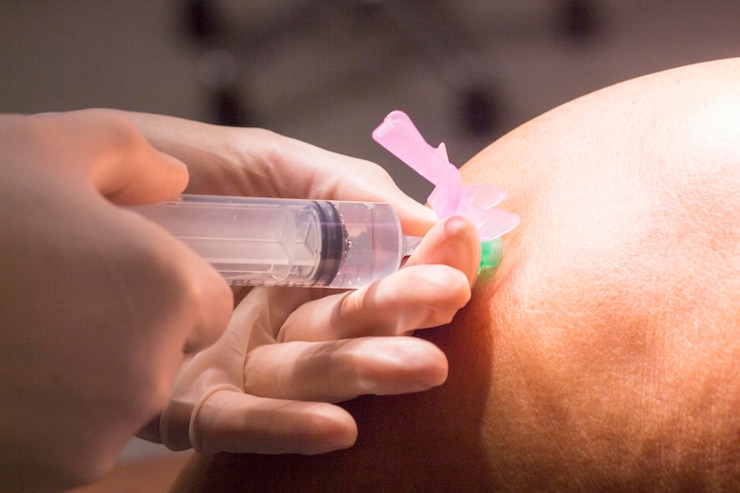 Foto primer plano de un médico inyectando a un paciente de rodillas