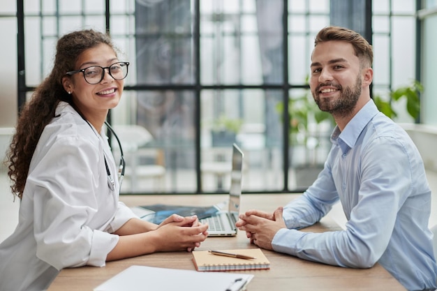 Primer plano médico y paciente mirando a la cámara