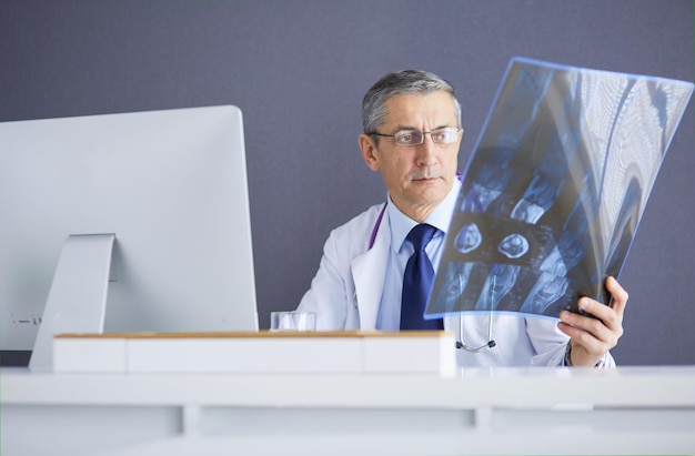 Primer plano de un médico varón sosteniendo una imagen de rayos x o roentgen