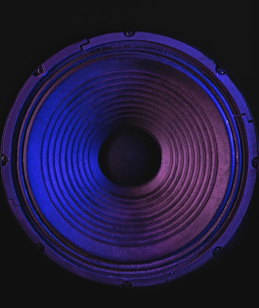 Foto primer plano de la membrana del altavoz sobre fondo negro con iluminación de colores.